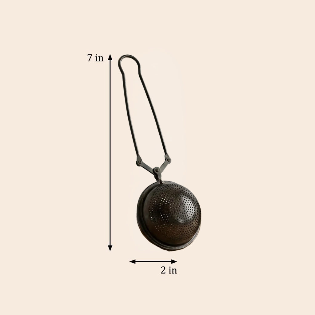 A metal tea infuser with a hanging loop, shown on a light beige background with dimension arrows indicating a height of 7 in and a diameter of 2 in.