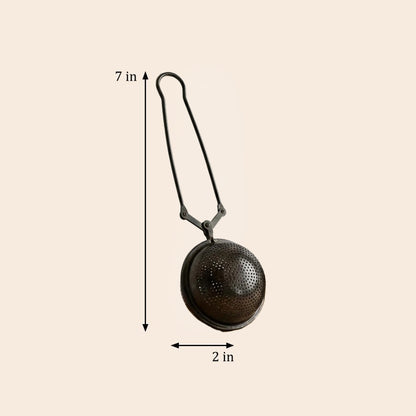 A metal tea infuser with a hanging loop, shown on a light beige background with dimension arrows indicating a height of 7 in and a diameter of 2 in.